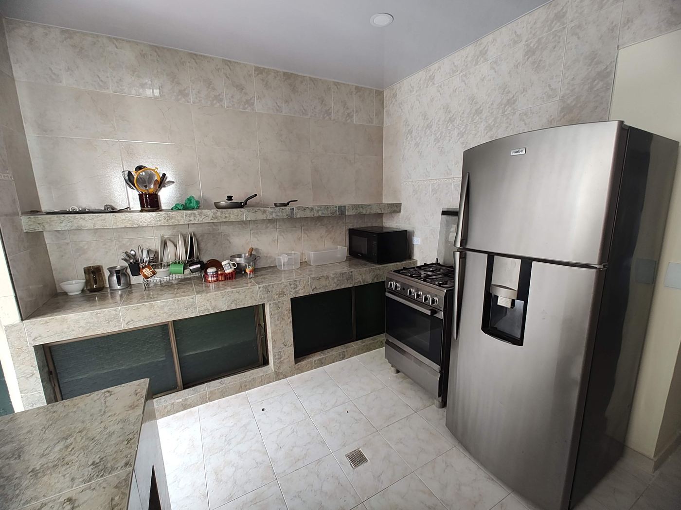 Cocina equipada con nevera, estufa con horno y microondas