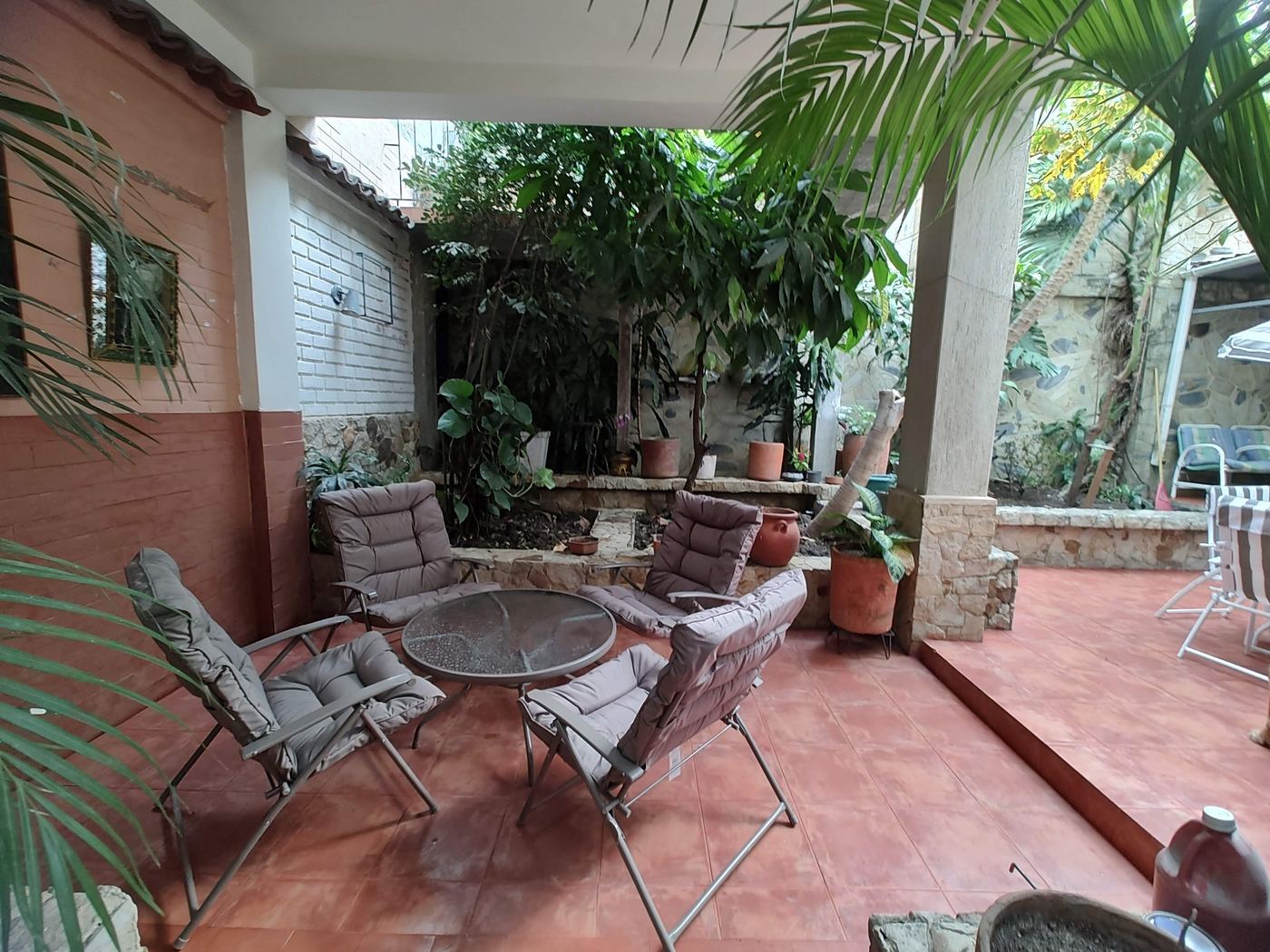 Patio cubierto junto al jardín de Herradura House